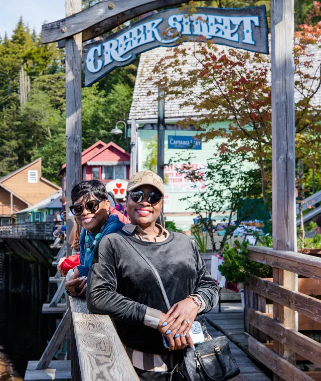 Smiling woman leaning on the rail of the walkway on Creek Street