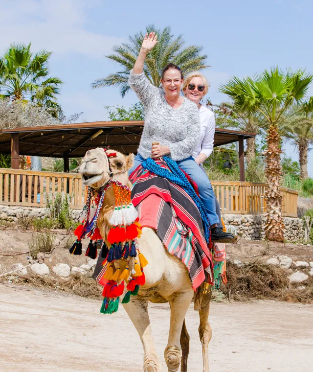 Two women riding a camel