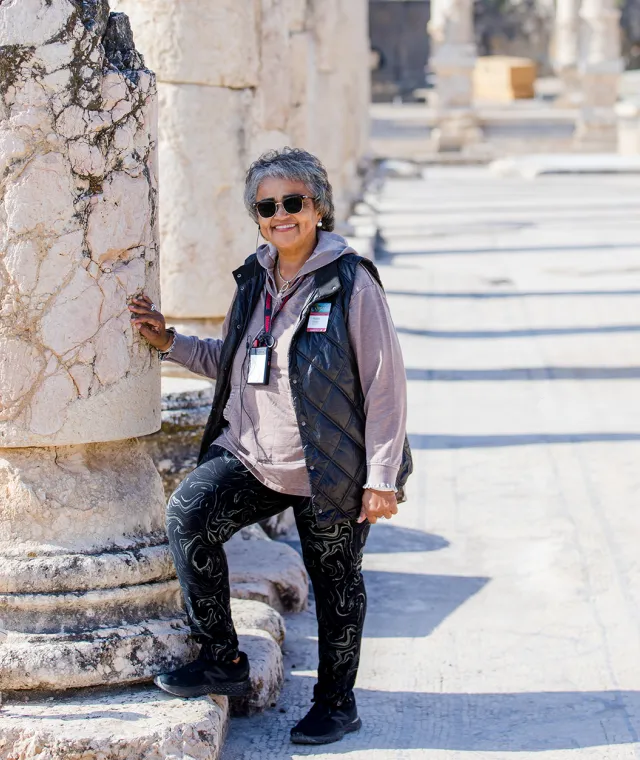 A woman standing near an ancient column